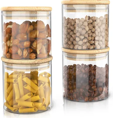 Four glass storage jars with bamboo lids are stacked in two columns of two.