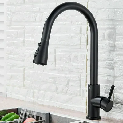 A black kitchen faucet with a pull-down sprayer is shown in front of a white brick backsplash.