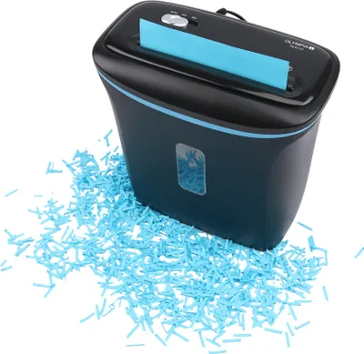 A black paper shredder with blue trim, shown on a white background with shredded blue paper scattered around its base.
