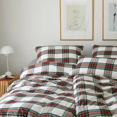 A bed with plaid bedding and pillows.