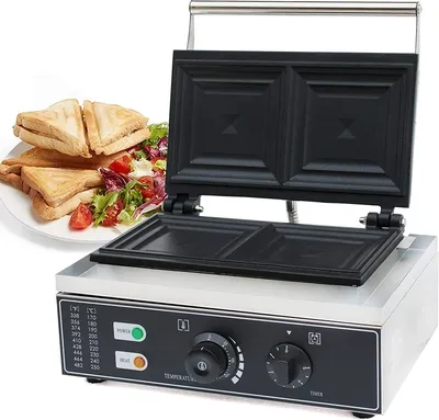 A sandwich maker with sandwiches and salad on a plate next to it.