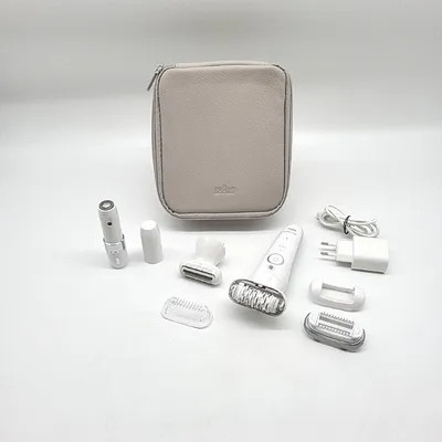 A collection of Braun Silk-epil 9 epilator attachments and accessories laid out on a white surface, with the storage case in the background.