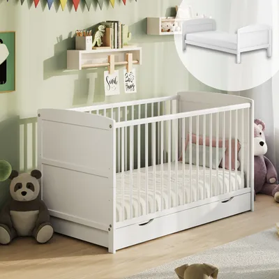 A nursery room with a white crib, stuffed animals, and decorations on the wall.