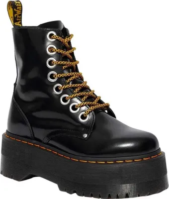A black Dr. Martens boot with a platform sole and yellow laces, shown against a white background.