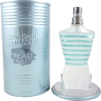 A bottle of Jean Paul Gaultier Le Beau Male Eau de Toilette and its cylindrical tin packaging are displayed against a white background.