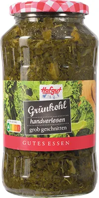 A glass jar of pickled kale with a red and white checkered lid and a label.