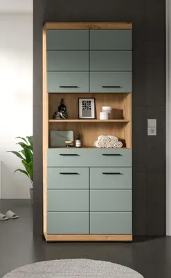 A tall cabinet with green doors and wooden accents, placed in a bathroom setting.