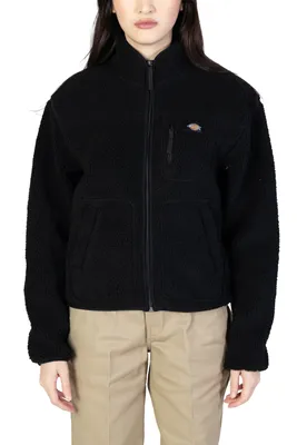 A woman wearing a black fleece jacket and tan pants.