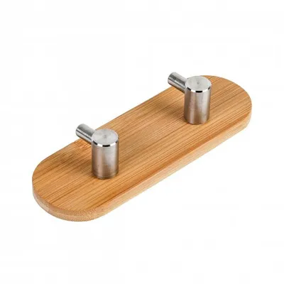 A wooden hook rack with two silver hooks on a white background.
