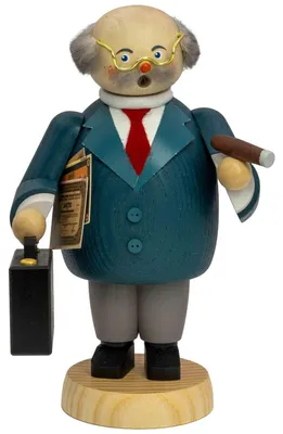 Ein hölzerner Räuchermann in Form eines Bankers trägt einen blauen Anzug mit roter Krawatte hält eine Zigarre in der einen Hand und einen Aktenkoffer in der anderen und steht auf einem runden Sockel
