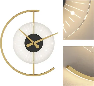 A modern wall clock with a gold frame and a white face with radiating light effects.