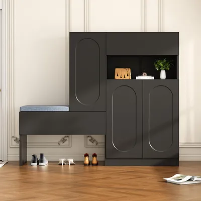A dark gray shoe cabinet with an integrated bench and blue cushion, placed in a room with wooden flooring and white paneled walls.