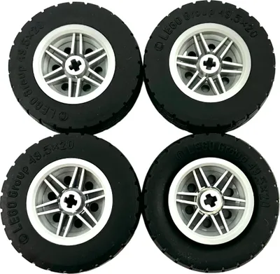 Four LEGO Technic tires with rims, arranged in a 2x2 grid.