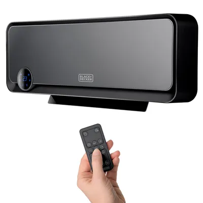 A Black & Decker heater is mounted on a wall, with a remote control held by a hand below it.
