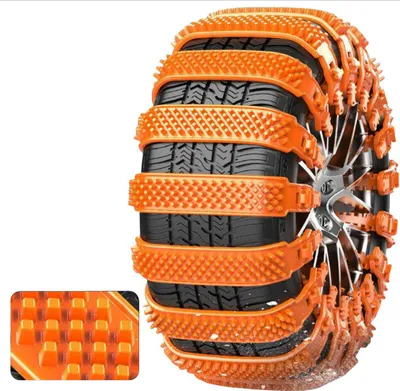 A close-up of a car tire fitted with orange snow chains, with a small inset showing a magnified view of the chain's texture.
