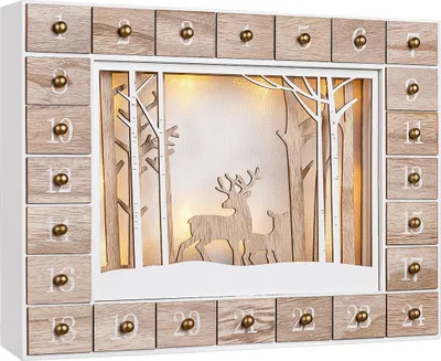 A wooden advent calendar with 24 drawers, featuring a winter scene with deer and trees illuminated by warm white LED lights.