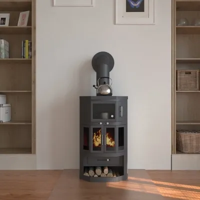 A black wood-burning stove with a kettle on top, placed in a room with bookshelves on either side.