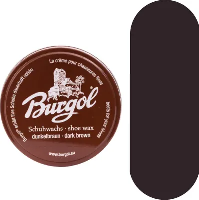 A round tin of shoe wax with text and a graphic on the lid, placed next to a solid dark brown oval shape.