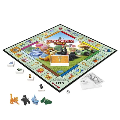 A Monopoly Junior board game is laid out on a white surface, with game pieces and money scattered around it.