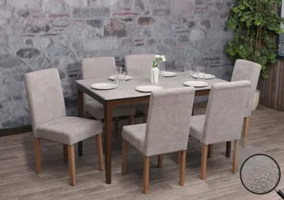 A dining set with a table and six chairs against a stone wall.