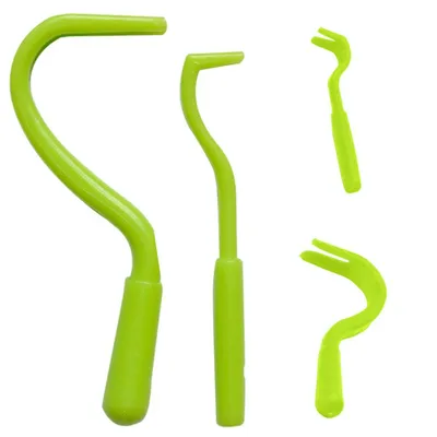 Four green tick removal tools of different sizes and shapes are arranged on a white background.