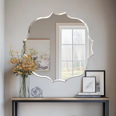 A decorative mirror is displayed above a console table with decorative items.