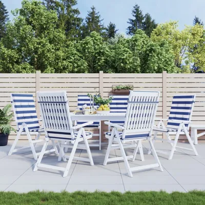 An outdoor patio set with chairs and a table, surrounded by trees and a wooden fence.