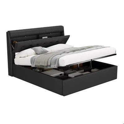 A black upholstered bed frame with the mattress lifted to reveal storage space underneath.