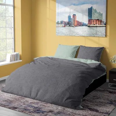 A bedroom scene with a bed, window, and artwork.