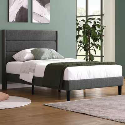 A bedroom scene with a bed, pillows, and a plant.