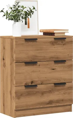 A wooden dresser with three drawers is shown against a white background. There are books and a plant on top of the dresser.