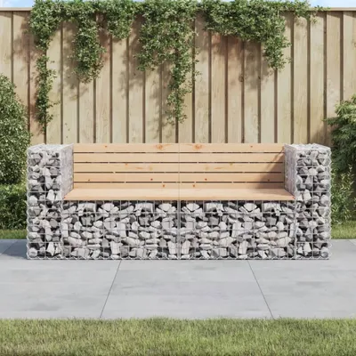 A gabion bench with a wooden seat sits on a paved patio in front of a wooden fence with hanging plants.
