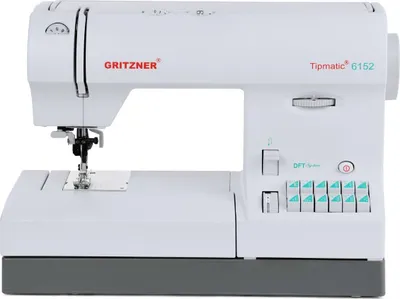 A white sewing machine with gray base and teal buttons is shown against a white background.