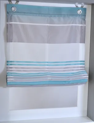 A striped Roman blind hanging in a window frame.