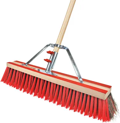 A close-up, studio shot of a broom head with a wooden handle and metal attachments.