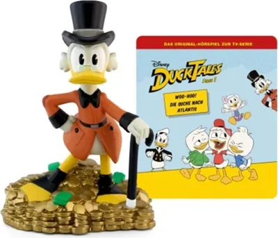A Disney DuckTales figurine of Scrooge McDuck standing on a pile of gold coins, next to a CD cover for the DuckTales Hörspiel (audio drama).