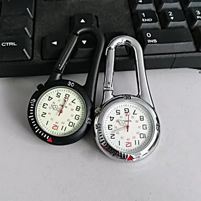 Two carabiner watches are placed on a keyboard.
