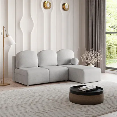 A modern living room with a light gray sectional sofa, a floor lamp, and a coffee table.