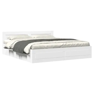 A white bed frame with a headboard and drawers, shown from a side angle with bedding.