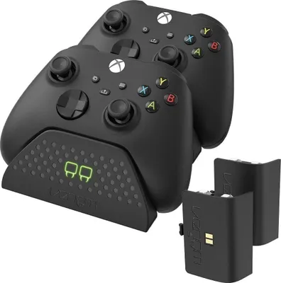 A black dual charging dock with two Xbox controllers and two rechargeable battery packs.