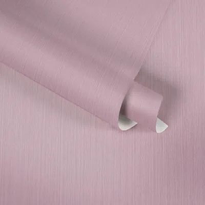 A close-up, angled view of a roll of pink textured wallpaper.