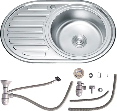 A stainless steel kitchen sink with a drainboard and a set of plumbing accessories laid out below it.