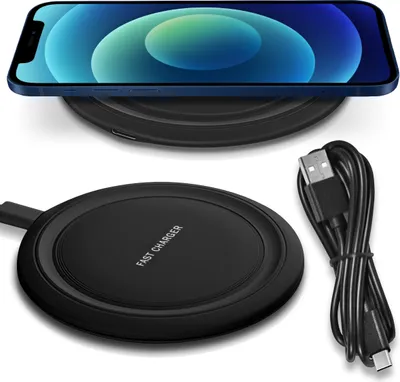 A smartphone is placed on a wireless charger, with a USB cable next to it.