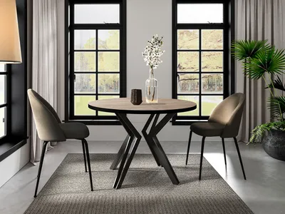 A round dining table with two chairs in a modern dining room setting.