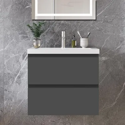A modern bathroom vanity with a white countertop and two gray drawers, set against a marble-patterned wall.