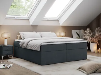 A bedroom with a bed, nightstand, and skylights.