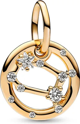 A close-up studio shot of a gold-colored zodiac charm with clear stones.
