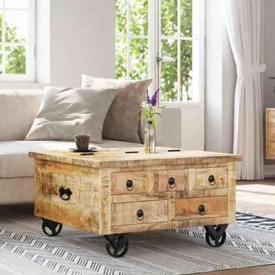A wooden coffee table with drawers and wheels in a living room setting.