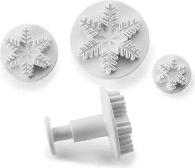 A set of three white snowflake-shaped cookie cutters on a white background.