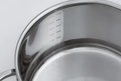 A close-up view of the interior of a stainless steel pot, showing measurement markings.